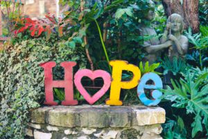 Colorful metal cutout of the word hope in a garden
