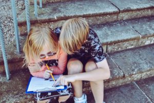 Picture of a boy helping a girl with homework.